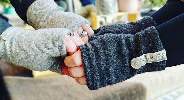 Two people's hands wearing fingerless gloves handmade by Kitten Mittens