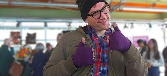 Man wearing purple fingerless recycled sweater gloves handmade by Kitten Mittens.