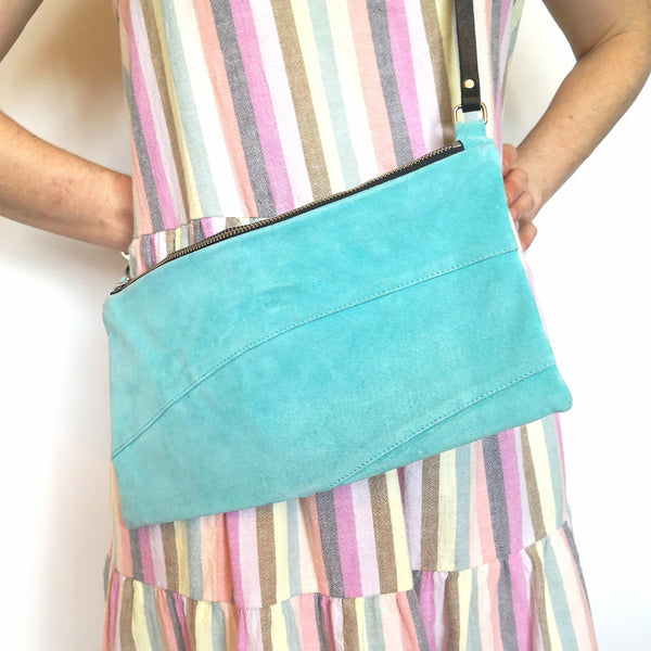 Woman wearing recycled aqua suede crossbody bag