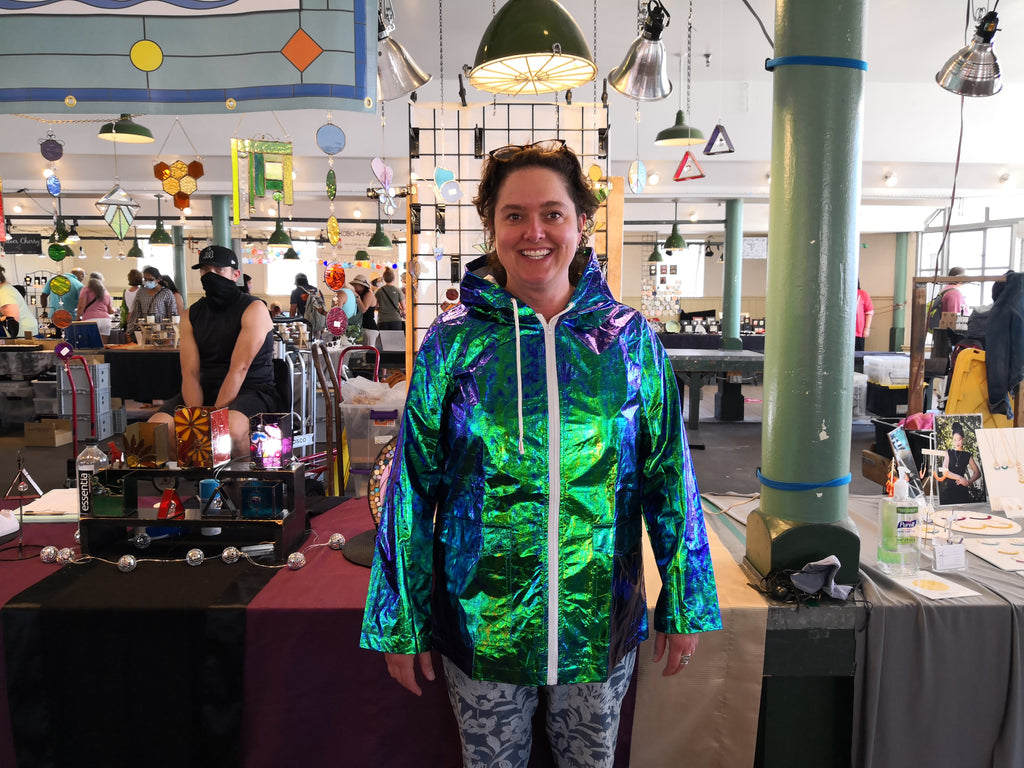 Woman wearing junebug holographic raincoat in front view