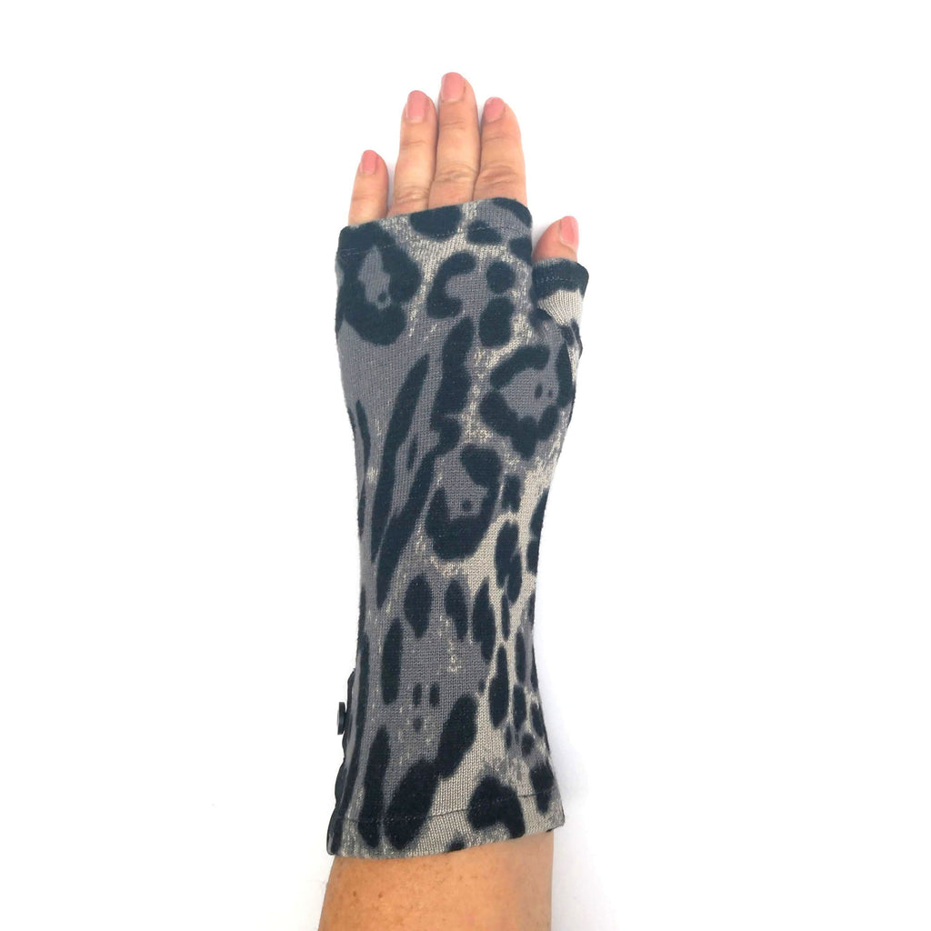 Hand wearing black and grey animal print fingerless mitten made from a recycled sweater