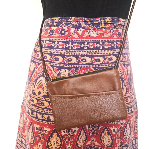 Woman in boho skirt and recycled brown leather minibag