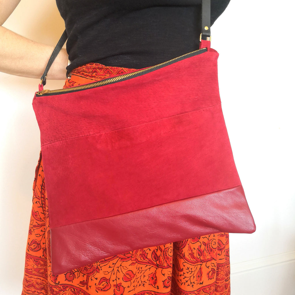 Person wearing crossbody bag in red recycled leather and suede