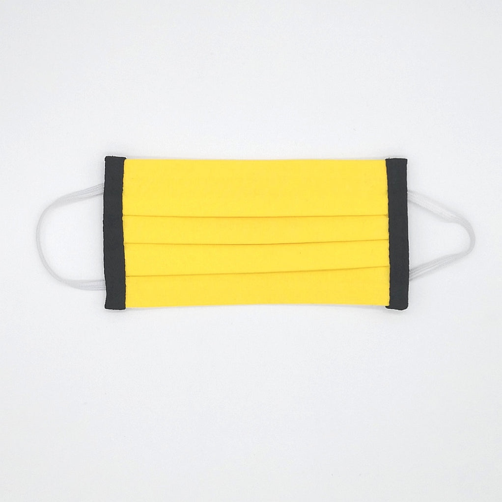 Reusable cotton face mask in bright yellow with black edging and white ear loops